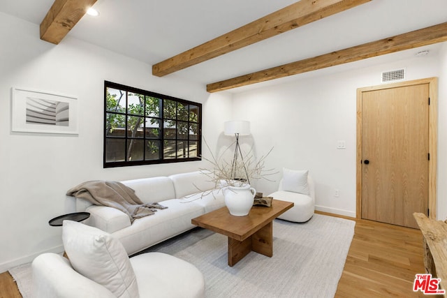 living room featuring beamed ceiling and light wood-type flooring