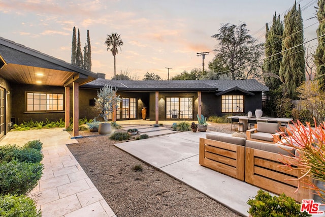 patio terrace at dusk with an outdoor hangout area and french doors