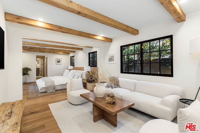 living room featuring beamed ceiling and light hardwood / wood-style flooring