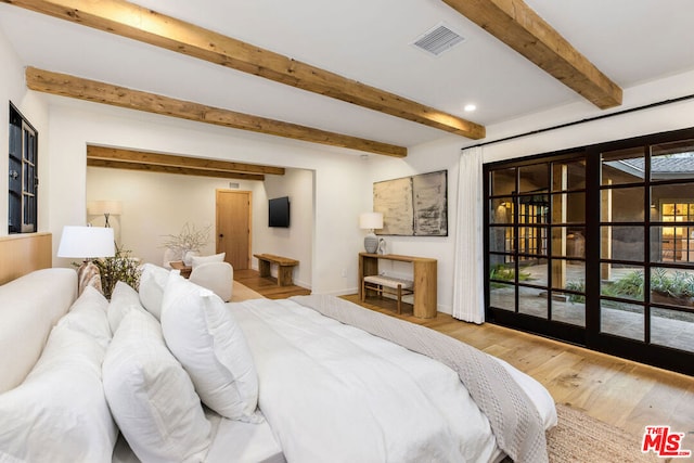 bedroom featuring hardwood / wood-style flooring and beam ceiling