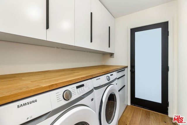 washroom with cabinets, independent washer and dryer, and light hardwood / wood-style flooring