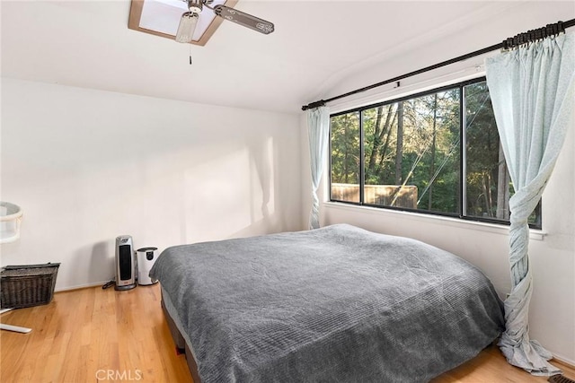 bedroom with hardwood / wood-style flooring, vaulted ceiling, and ceiling fan