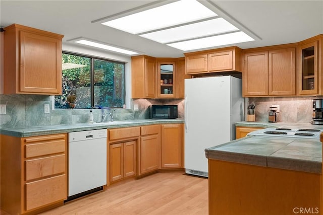 kitchen featuring tasteful backsplash, white appliances, sink, and light hardwood / wood-style flooring