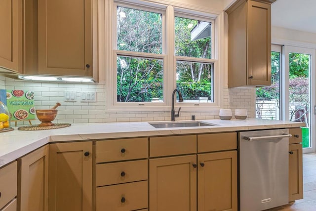 kitchen featuring stainless steel dishwasher, sink, decorative backsplash, and light brown cabinets