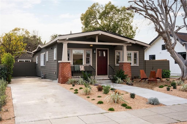 craftsman house with covered porch, brick siding, and driveway