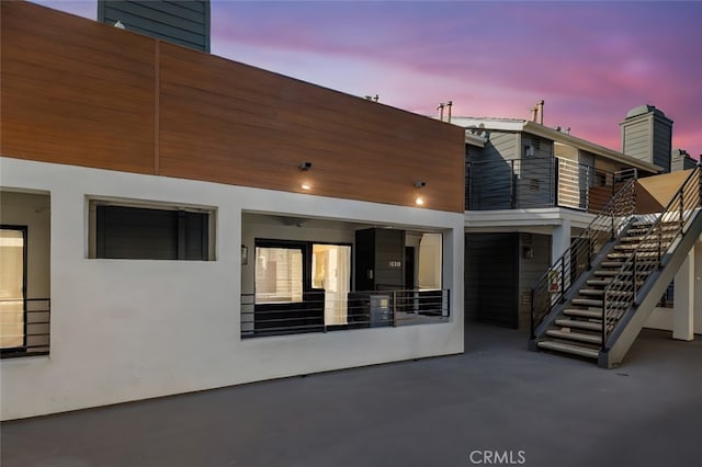 back house at dusk with a patio area