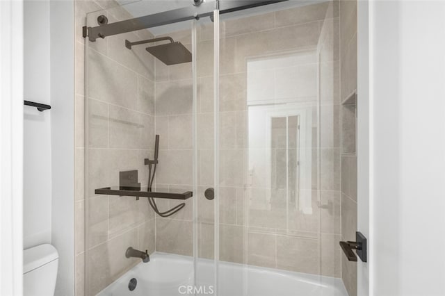 bathroom with shower / bath combination with glass door and toilet