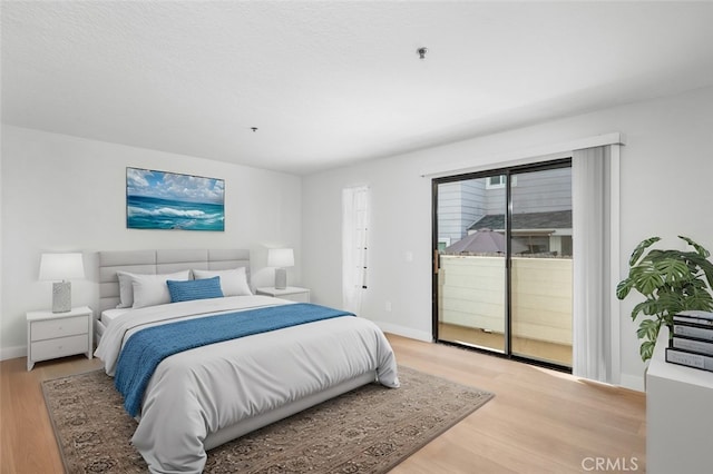 bedroom with access to exterior and light hardwood / wood-style floors