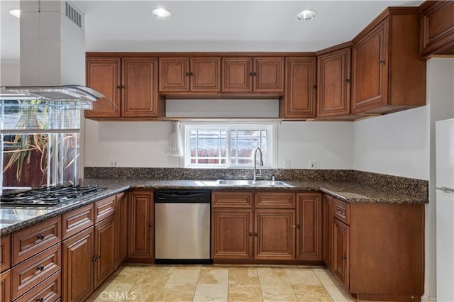 kitchen with sink, island range hood, stainless steel appliances, and dark stone counters