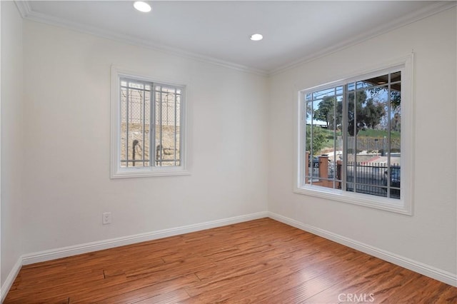 empty room featuring ornamental molding and hardwood / wood-style floors