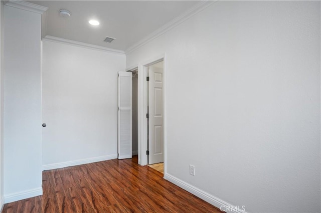 empty room with ornamental molding and dark hardwood / wood-style floors