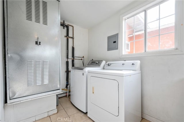 washroom featuring electric panel, washing machine and dryer, and light tile patterned flooring