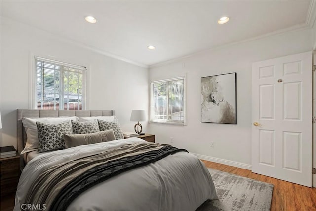 bedroom with multiple windows, hardwood / wood-style flooring, and ornamental molding