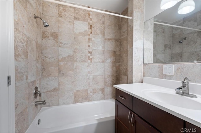 bathroom with tiled shower / bath and vanity