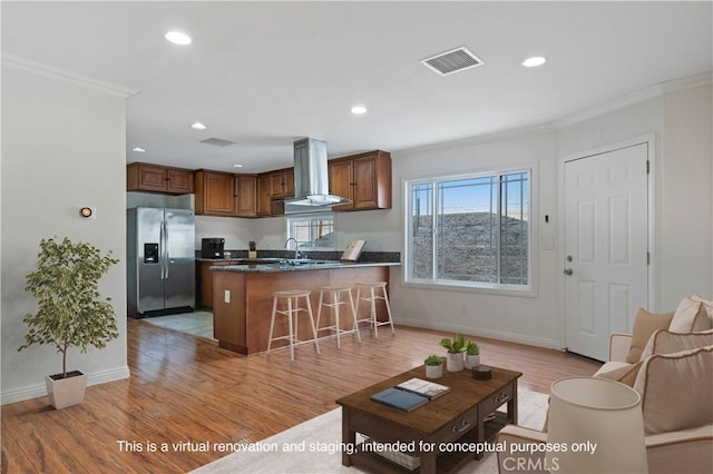 kitchen featuring stainless steel refrigerator with ice dispenser, extractor fan, ornamental molding, kitchen peninsula, and light wood-type flooring