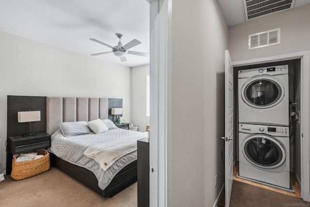 carpeted bedroom featuring stacked washer / drying machine and ceiling fan