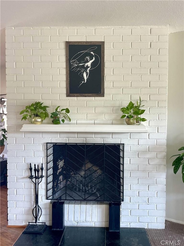 interior details with a brick fireplace and a textured ceiling