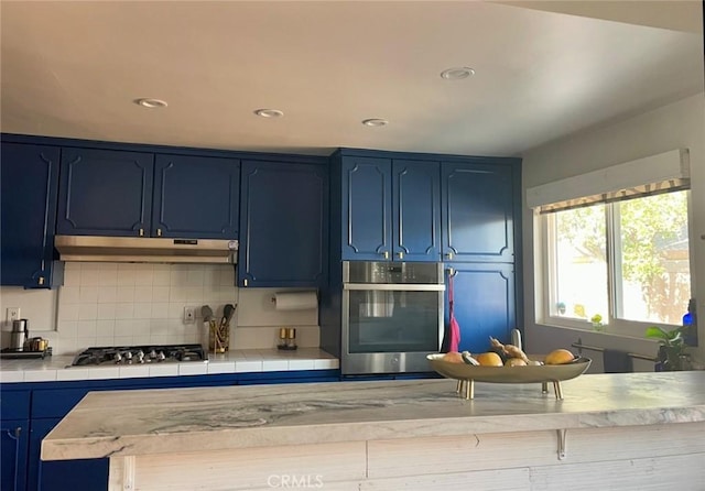 kitchen featuring blue cabinets, backsplash, and appliances with stainless steel finishes