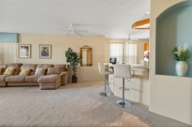 carpeted living room with ceiling fan