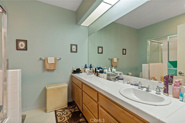 bathroom with vanity and a shower with shower door