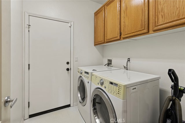 washroom featuring cabinets and washing machine and clothes dryer