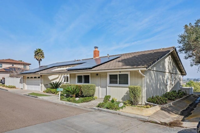 view of front of home with a garage and solar panels