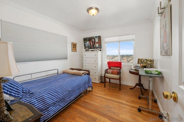 bedroom featuring ornamental molding and hardwood / wood-style floors