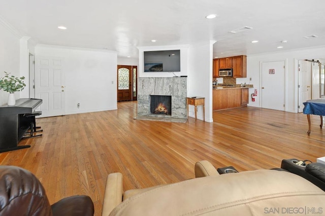 living room featuring ornamental molding and light hardwood / wood-style floors