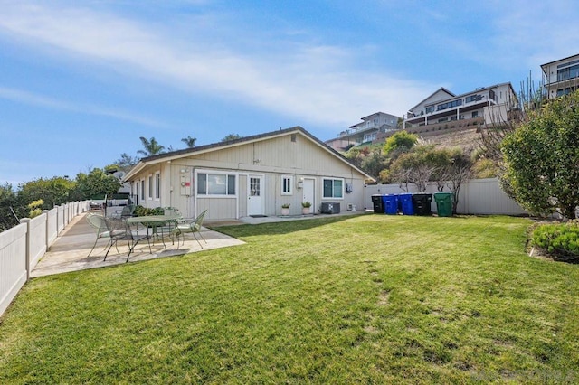 rear view of house with a yard, central AC, and a patio area