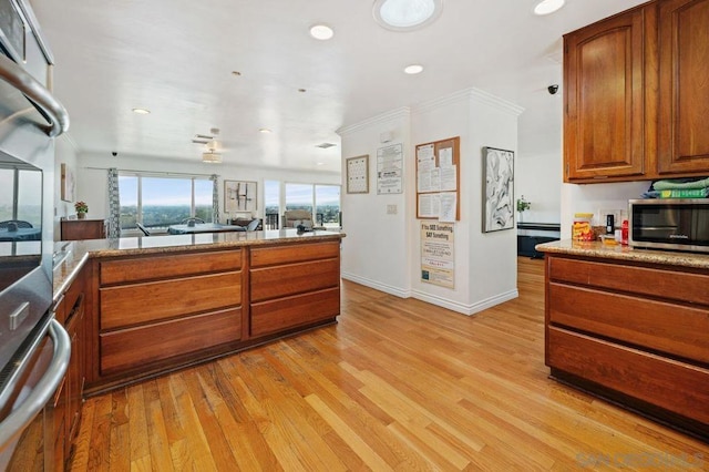 kitchen with crown molding, stainless steel appliances, and light hardwood / wood-style floors