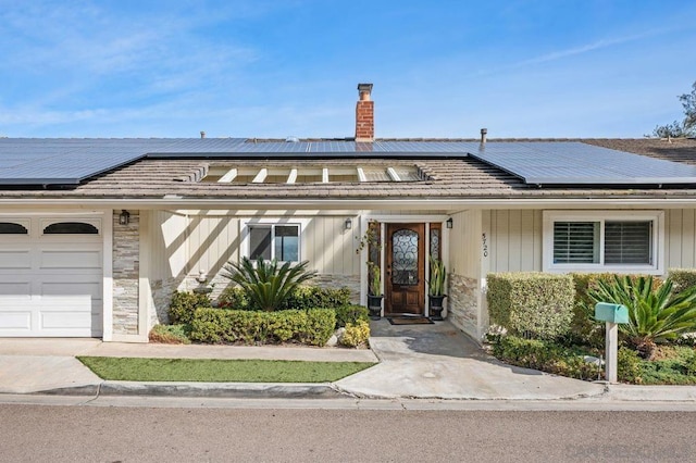 view of front of property featuring a garage and solar panels