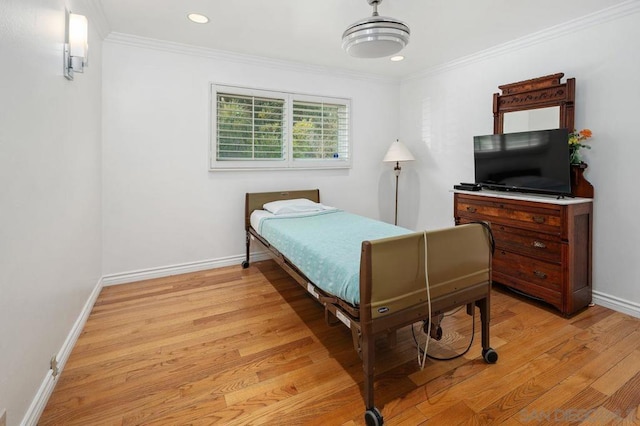 bedroom featuring ornamental molding and light hardwood / wood-style flooring