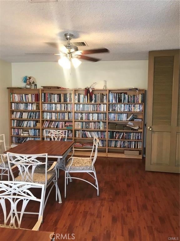 living area featuring ceiling fan, hardwood / wood-style floors, and a textured ceiling