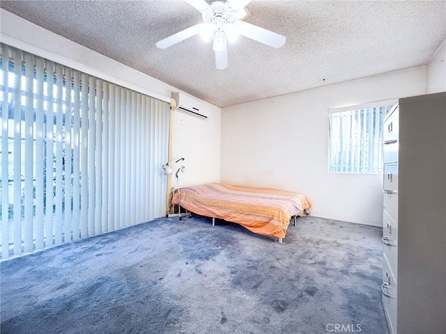 bedroom with ceiling fan, carpet flooring, a textured ceiling, and a wall unit AC