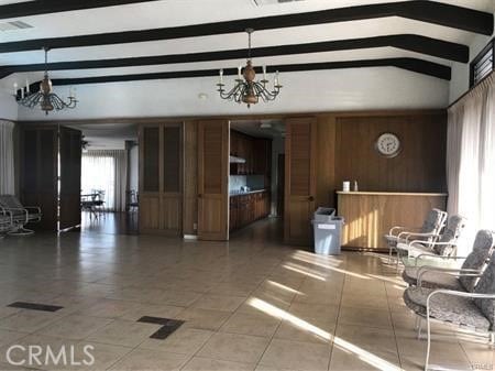 interior space featuring beamed ceiling and a chandelier