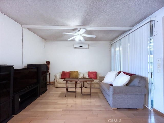 living area featuring ceiling fan, a wall mounted AC, a textured ceiling, and light wood-type flooring