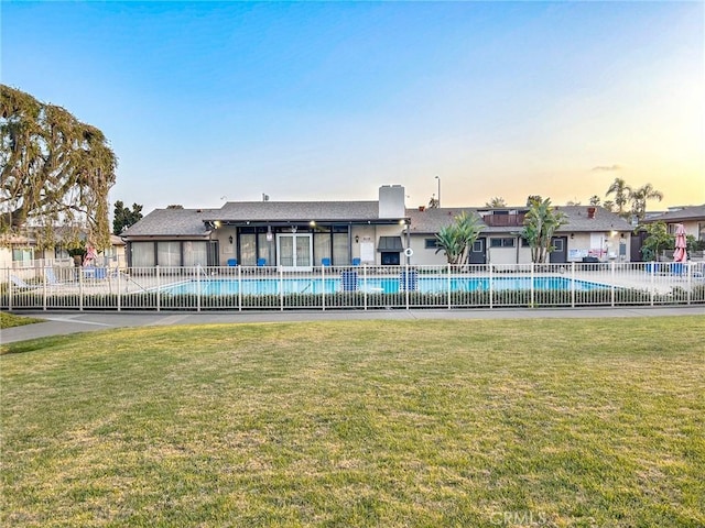 view of pool with a lawn