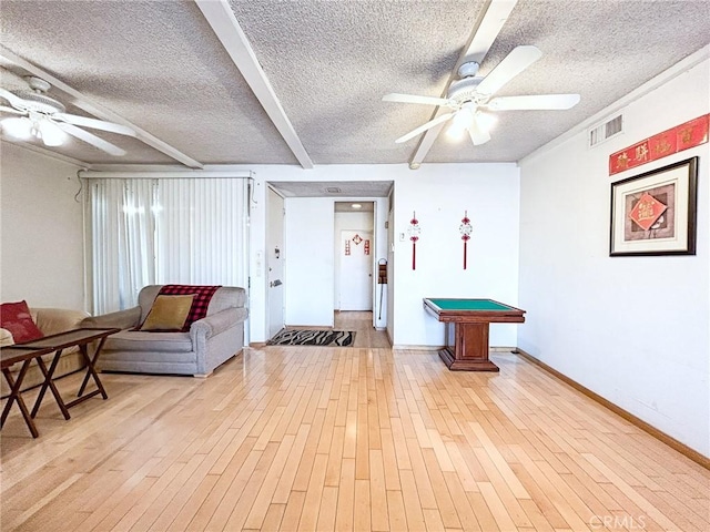 interior space with ceiling fan, light hardwood / wood-style floors, and a textured ceiling