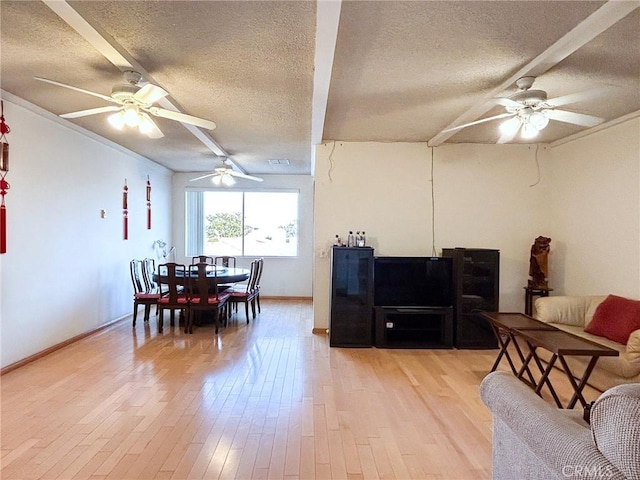 living room with ceiling fan, light hardwood / wood-style flooring, and a textured ceiling