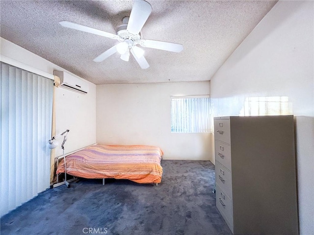 bedroom featuring ceiling fan, a wall unit AC, a textured ceiling, and dark colored carpet