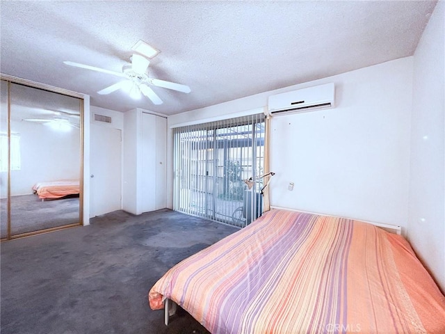 bedroom featuring dark colored carpet, ceiling fan, a textured ceiling, and a wall unit AC