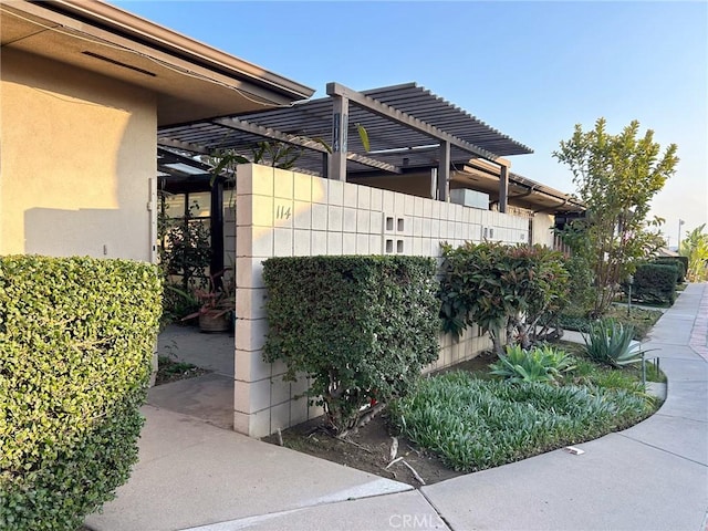 view of property exterior with a pergola