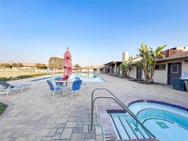 view of swimming pool with a hot tub and a patio