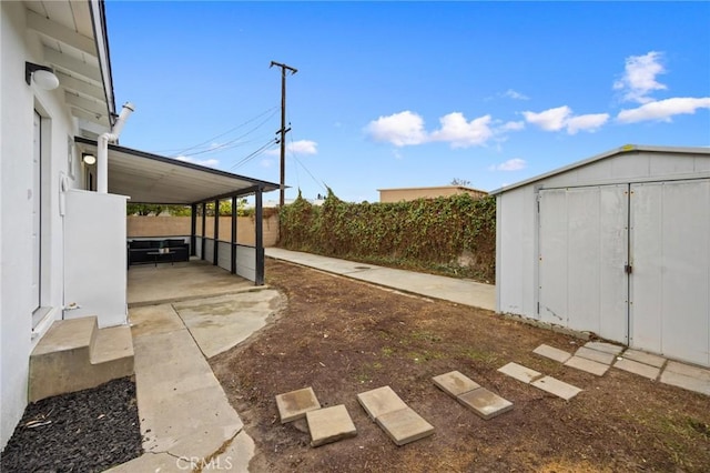 view of yard featuring fence, a storage unit, and an outdoor structure