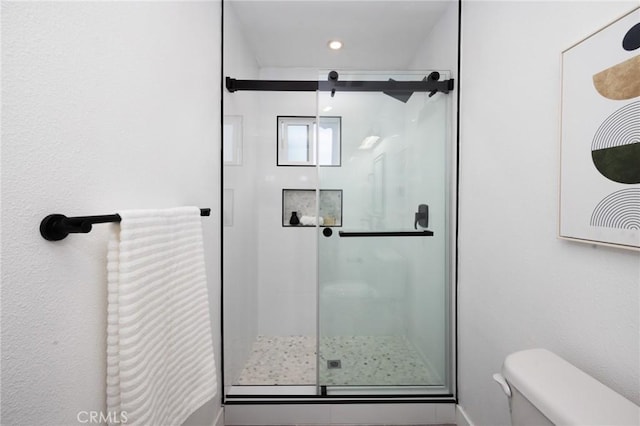 bathroom featuring a stall shower, toilet, and recessed lighting