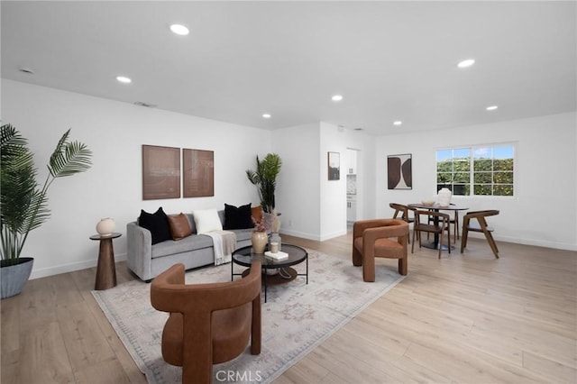 living area with recessed lighting, baseboards, visible vents, and light wood finished floors