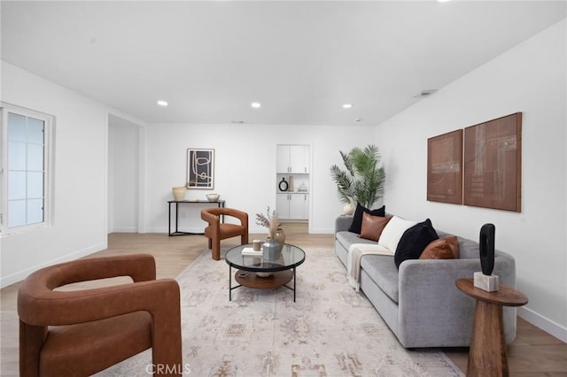 living area featuring light wood-type flooring, baseboards, and recessed lighting