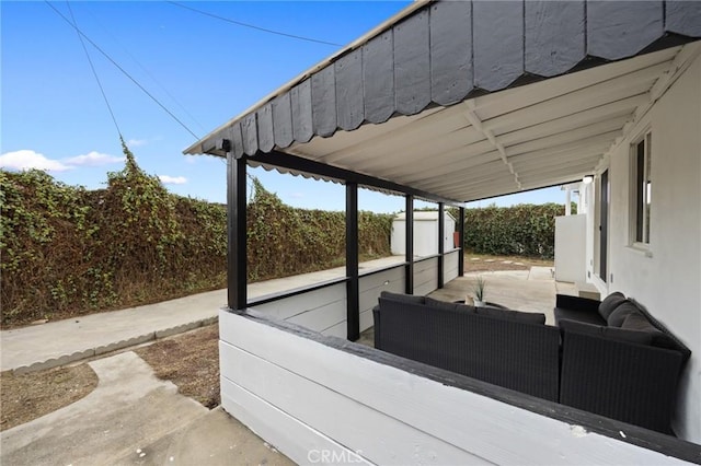 view of patio with an outdoor hangout area, a storage unit, an outbuilding, and fence