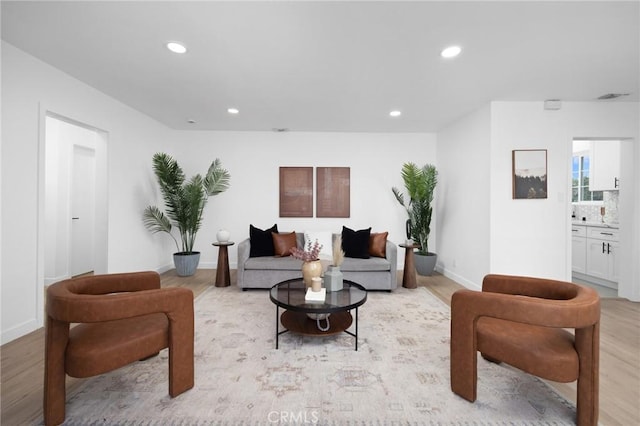 living room with baseboards, recessed lighting, visible vents, and light wood-style floors