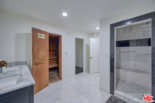 bathroom with vanity and a tile shower